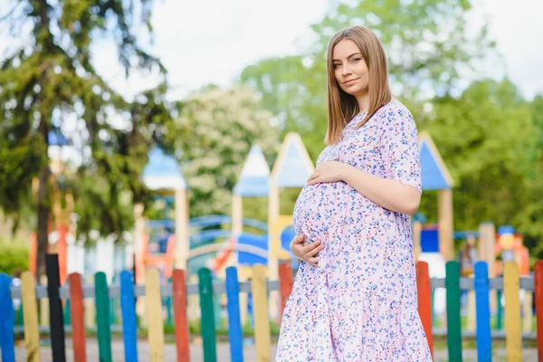 Вагітна Жінка Стоїть Парку Біля Дитячого Майданчика Діти Грають — стокове фото