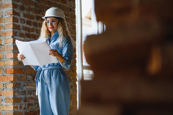 Warehouse woman worker. Woman builder in hardhat. Girl engineer or architect. Home renovation. Quality inspector. Construction job occupation. Construction worker. Lady at construction site.