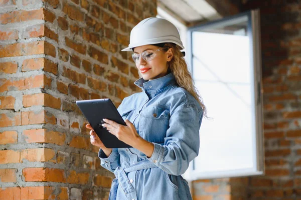 Warehouse woman worker. Woman builder in hardhat. Girl engineer or architect. Home renovation. Quality inspector. Construction job occupation. Construction worker. Lady at construction site.