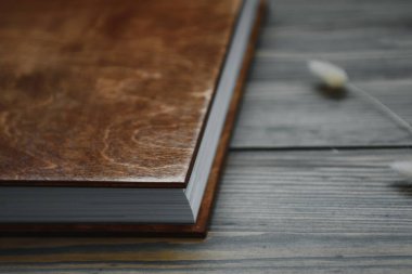 Kabartmalı aile fotoğrafı defteri. Ahşap bir arka planda fotoğraf kitabı. Ahşap kaplı kahverengi fotoğraf kitabı. Sert kapaklı fotoğraf albümü. Düğün fotoğrafı albümü.