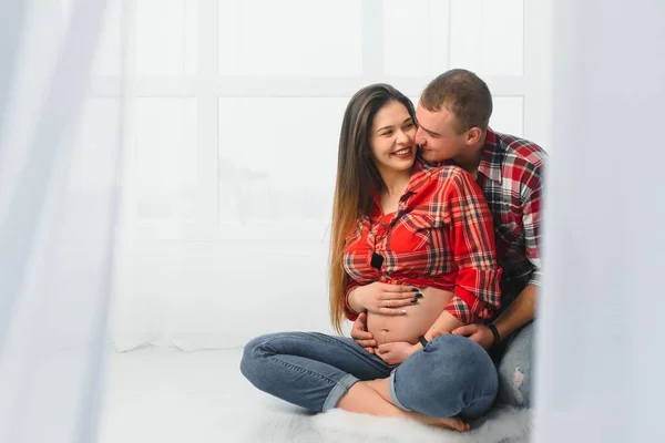 Amare Uomo Abbracciare Moglie Incinta Dietro Piedi Vicino Alla Finestra — Foto Stock