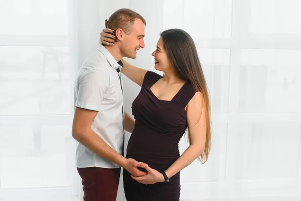Liebender Mann Umarmt Seine Schwangere Frau Von Hinten Fenster Stehend — Stockfoto