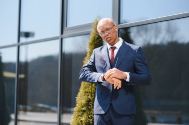 İş ortamında yürüyen yakışıklı bir işadamının portresi.