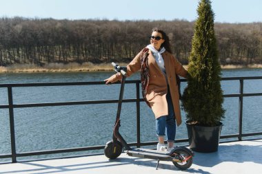 Elektrikli scooter kullanan uzun namlulu kadın, modern nesil.