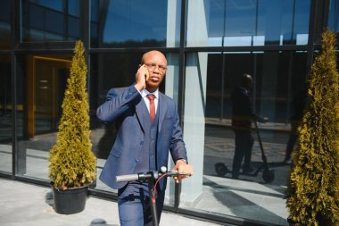 Elektrikli scooter süren genç Afrikalı işadamı