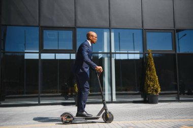 Elektrikli scooter süren genç Afrikalı işadamı