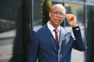 Dışarıda duran kendinden emin Afrikalı iş adamının portresi.