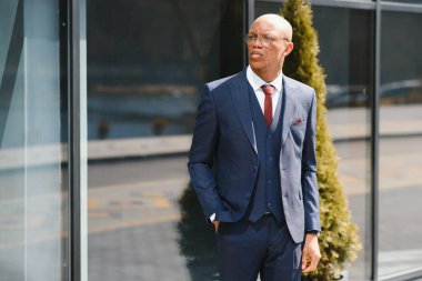 Dışarıda duran kendinden emin Afrikalı iş adamının portresi.