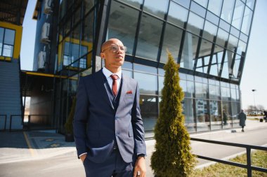 Dışarıda duran kendinden emin Afrikalı iş adamının portresi.