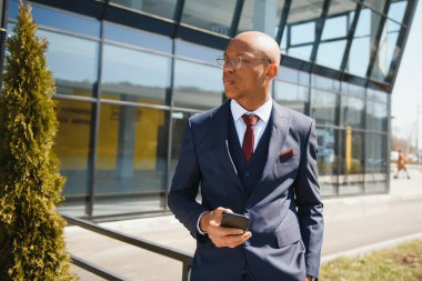 İş ortamında yürüyen yakışıklı bir işadamının portresi.