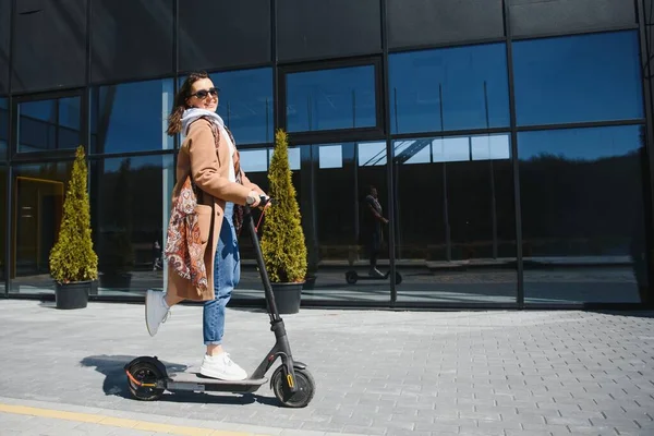 Egy Fiatal Gyönyörű Lány Áll Elektromos Robogója Mellett Mosolyog Üzletileg — Stock Fotó