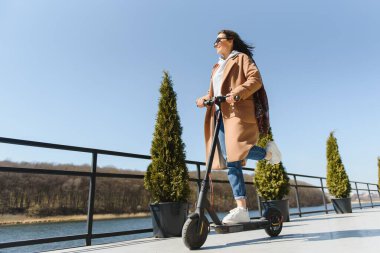 Elektrikli scooter kullanan uzun namlulu kadın, modern nesil.