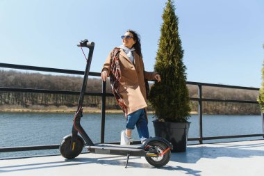 Elektrikli scooter kullanan uzun namlulu kadın, modern nesil.