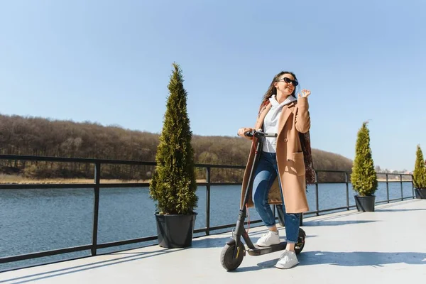 Junge Schöne Frau Jacke Lächelt Und Fährt Mit Einem Elektroroller — Stockfoto