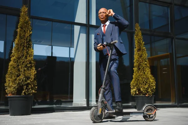 Knappe Afrikaan Man Dragen Jas Glimlachen Terwijl Paardrijden Elektrische Scooter — Stockfoto