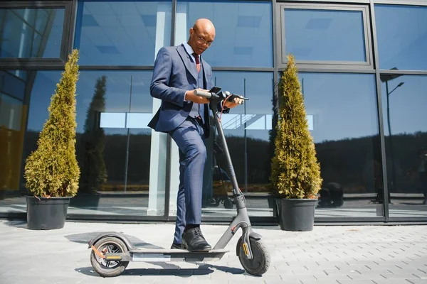 Happy Afro 30S Man Controleren Van Zijn Telefoon Tijdens Scooter — Stockfoto