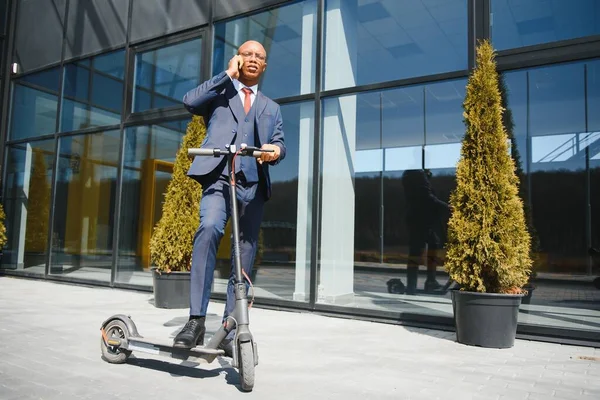 Knappe Afrikaan Man Dragen Jas Glimlachen Terwijl Paardrijden Elektrische Scooter — Stockfoto