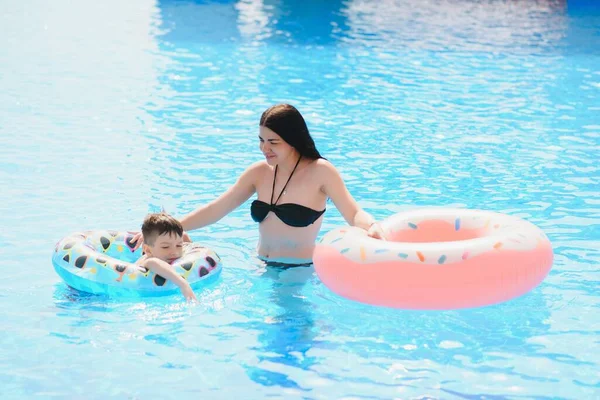 水泳プールで遊んでいる幸せな子供と女性 夏休みのコンセプト — ストック写真