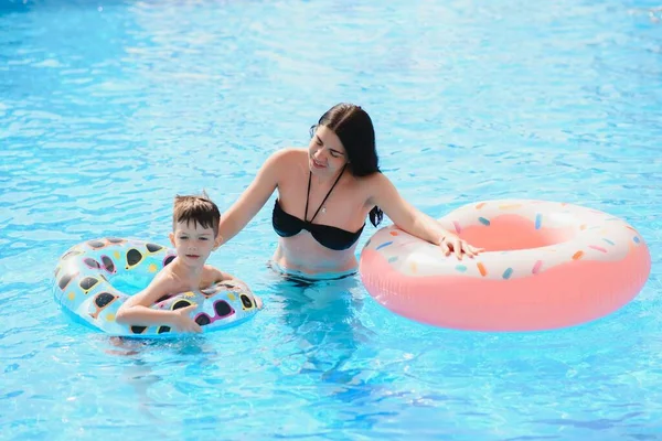 熱帯リゾートの屋外スイミングプールでの母親と赤ちゃん 子供は泳ぐことを学ぶ 母親と子供が水で遊んでいる エキゾチックな目的地で家族の夏休み 子供のためのアクティブで健康的なスポーツ — ストック写真