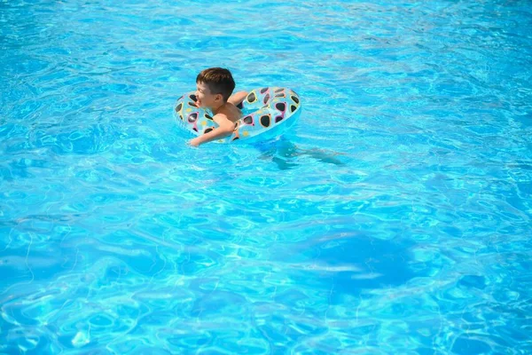 子供の夏休み プールで泳ぐ子供 子供たちはアクアパークで楽しんでいます インフレータブルゴムサークルの面白い少年 アトラクションのコンセプト — ストック写真