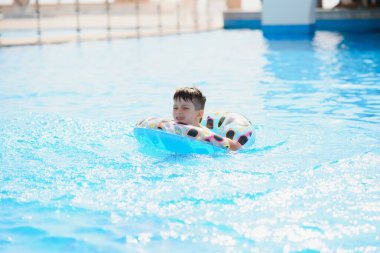 Mutlu çocuk yüzme havuzunda oynuyor. Yaz tatili kavramı