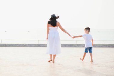 Mutlu aile anne ve oğlu yazın deniz kenarında sahilde.