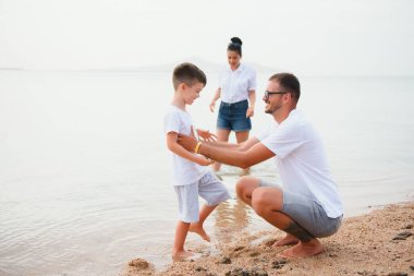 Mutlu bir aile sahilde yürüyor.