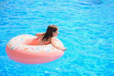 Neşeli erkek ve kız kardeşler havuzda yüzüyor