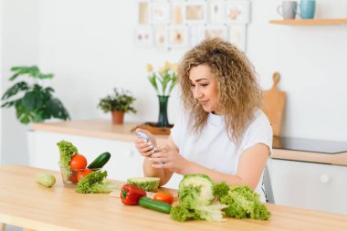 Genç bir kadın mutfağında sebze salatası hazırlıyor. Sağlıklı yaşam tarzı kavramı. Karışık sebzeli güzel bir kadın..