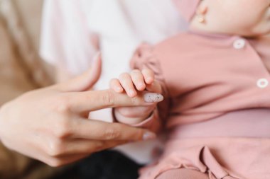 Mutlu aile annesi yeni doğmuş bebekle oynuyor.