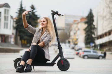 Elektro scooterlı genç bir kadının portresi