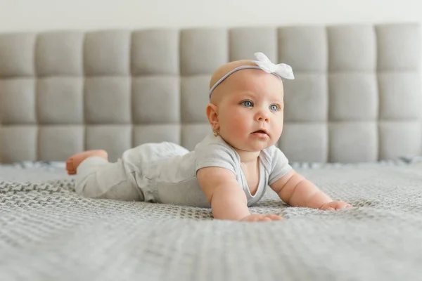可爱的7个月小女孩穿着尿布躺在床上玩耍 — 图库照片