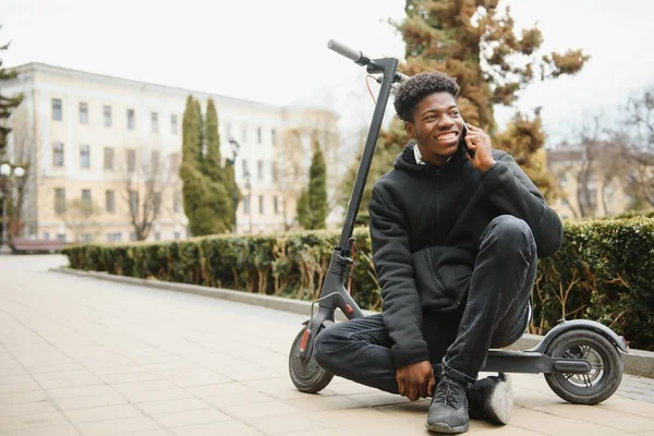 Een Jonge Afrikaan Met Elektrische Scooter Stad Het Concept Van — Stockfoto