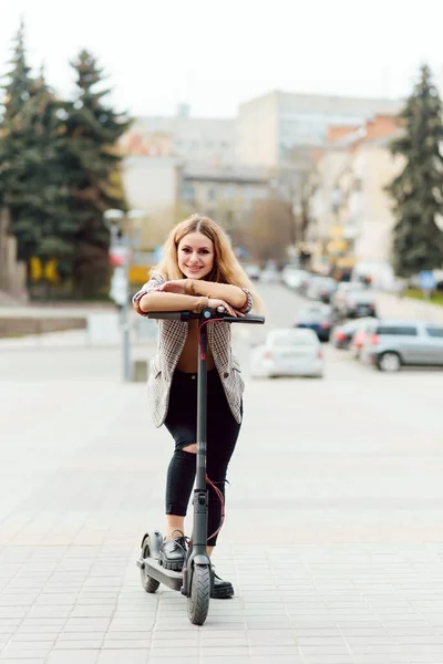 Portrait of a young woman with electro scooter