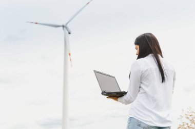 Araştırmacı rüzgar santralindeki ölçümleri analiz ediyor.