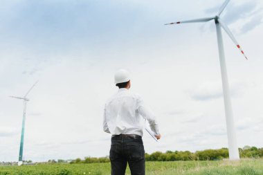 Rüzgâr Çiftliği 'ndeki proje müdürünü denetleyen mühendis. Çevrede çalışan adam.