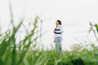 Araştırmacı rüzgar santralindeki ölçümleri analiz ediyor.