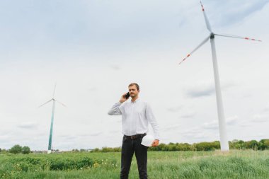 Rüzgâr Çiftliği 'ndeki proje müdürünü denetleyen mühendis. Çevrede çalışan adam.