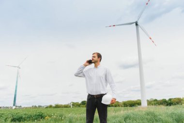 Rüzgâr Çiftliği 'ndeki proje müdürünü denetleyen mühendis. Çevrede çalışan adam.