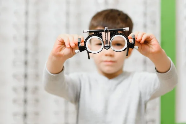 眼科診療所で裁判フレームを見せる子供の男の子 — ストック写真