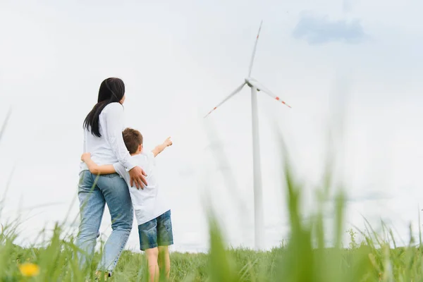 Alternative energy, wind farm and happy time with your family. Happy mother on the road with his son on vacation and escape to nature.
