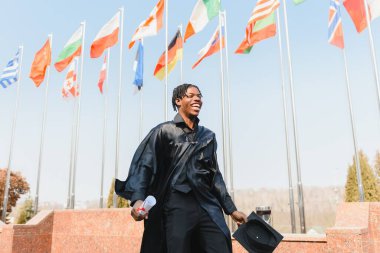 Üniversite mezuniyet kutlamasında gülümseyen bir adam.