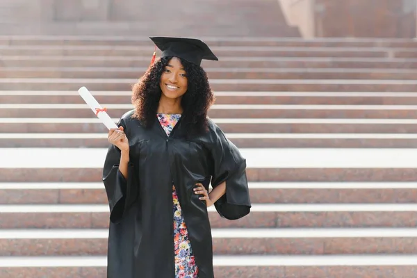 快乐的非洲裔美国女毕业生站在大学大楼前 — 图库照片