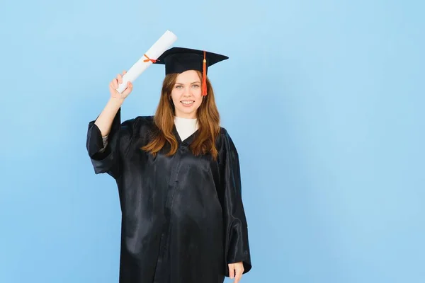 漂亮的女人 戴着毕业典礼帽 身穿礼袍 手握学位 面带微笑 面带微笑 面带微笑 显得积极而快乐 — 图库照片