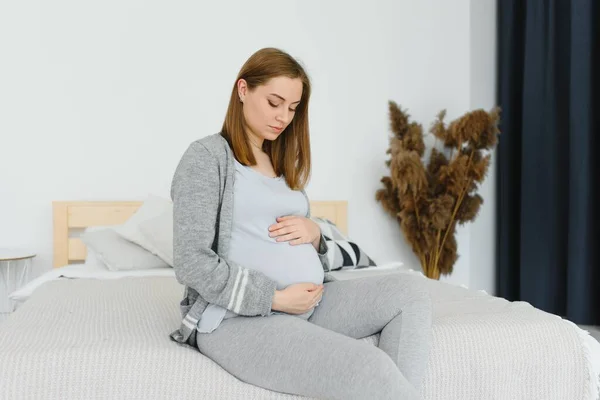 Güzel Hamile Kadın Yatak Odasında Karnının Üstünde Ele Tutuşuyor Bebek — Stok fotoğraf