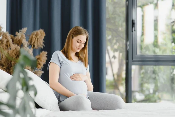 Gravid Ung Europeisk Kvinna Sitter Stor Säng Och Smeker Sin — Stockfoto