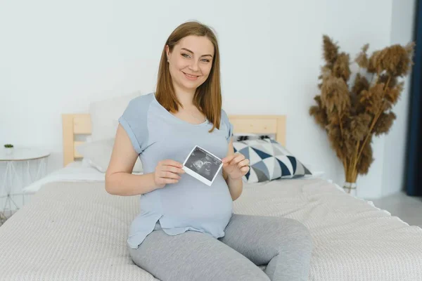 Schwangere Hält Ihren Bauch Und Ein Foto Ihres Ultraschalls — Stockfoto