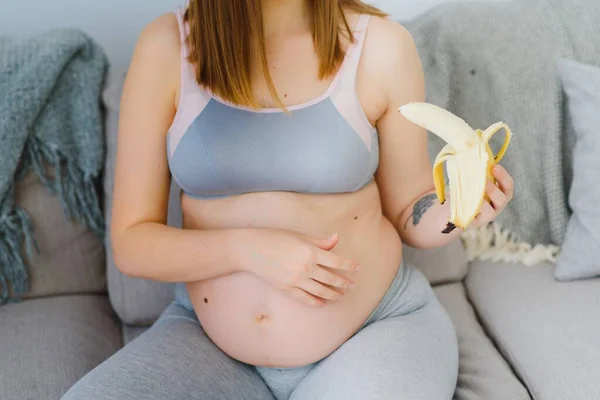 妊娠中の女性は彼女の手のバナナ — ストック写真