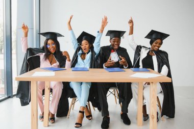 Eğitim, mezuniyet ve halk konsepti - Havan topu ve diplomalı bekarlık elbisesi giyen mutlu uluslararası lisansüstü öğrencileri grubu