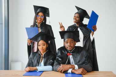 Eğitim, mezuniyet ve halk konsepti - Havan topu ve diplomalı bekarlık elbisesi giyen mutlu uluslararası lisansüstü öğrencileri grubu